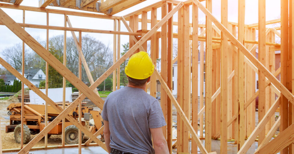 Contractor in hard hat framing walls, the kind of work that requires a building permit